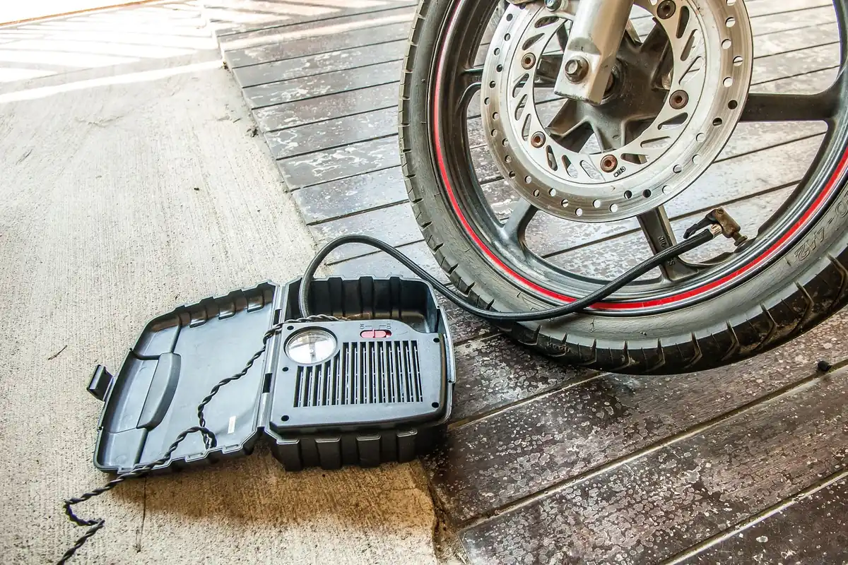 A portable air inflator hooked up to a motorcycle tire