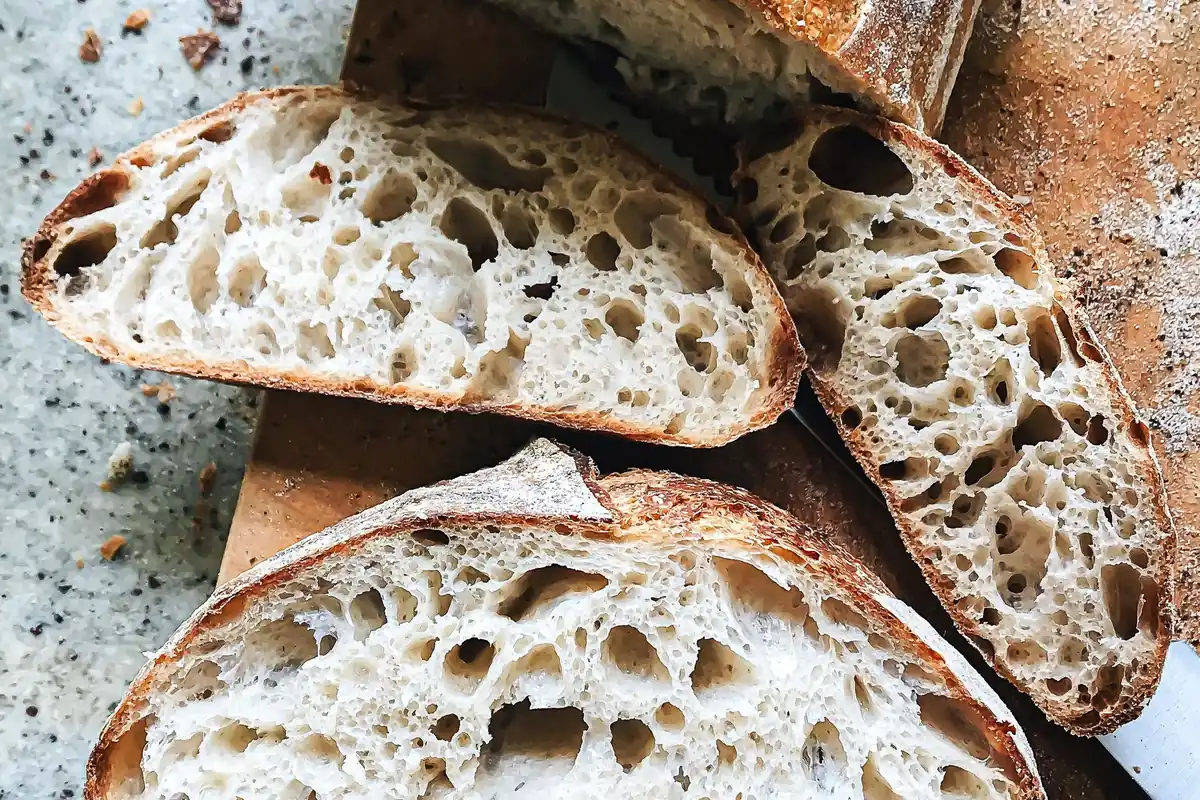 Sliced sourdough bread showing an open, airy crumb
