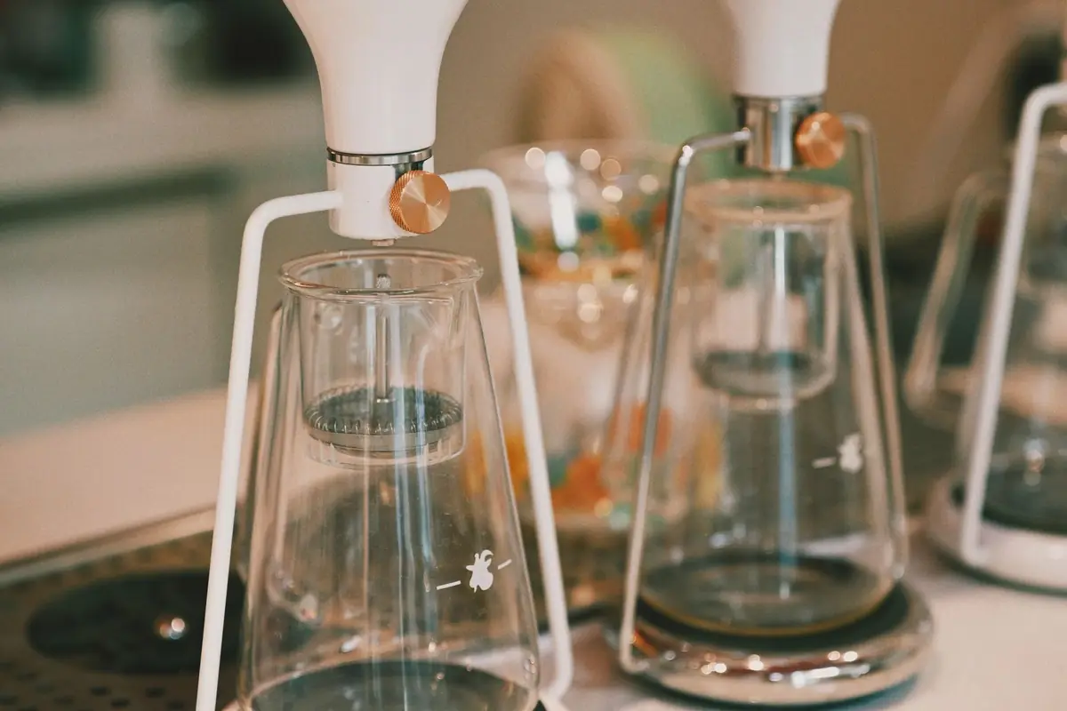 Glass pour-over coffee brewers lined up on a counter
