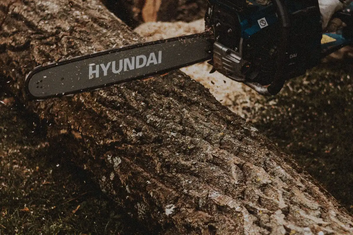 An electric chainsaw cutting through a large log