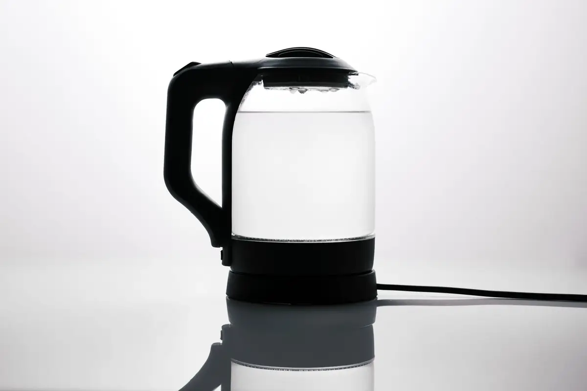 A close-up of a glass electric kettle and its lid