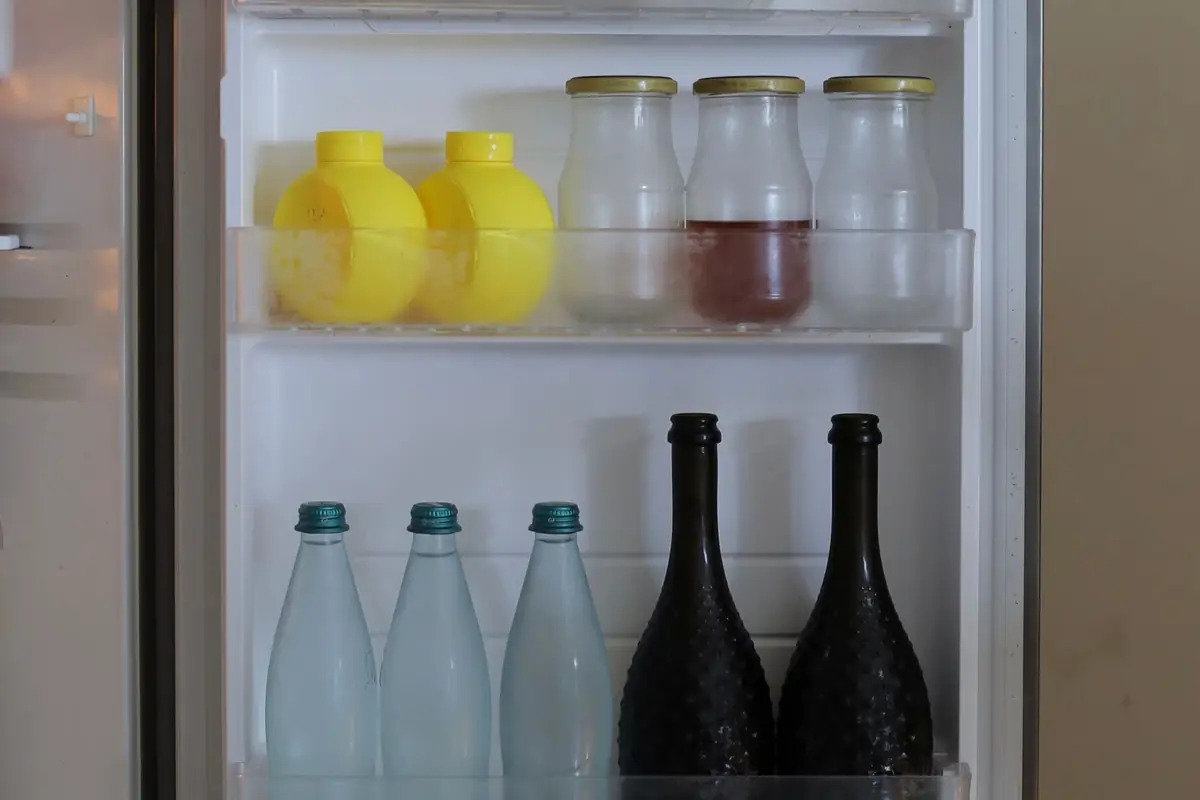 An open refrigerator door with bottles and jars on the shelves