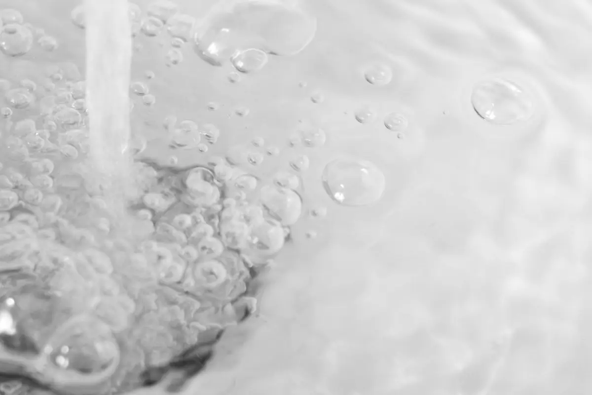 Water running into a sink with bubbles