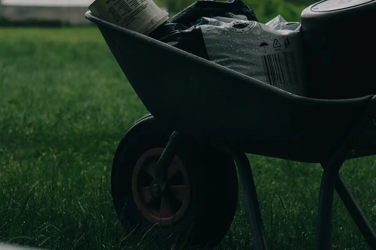 A wheelbarrow loaded with garden supplies on the grass