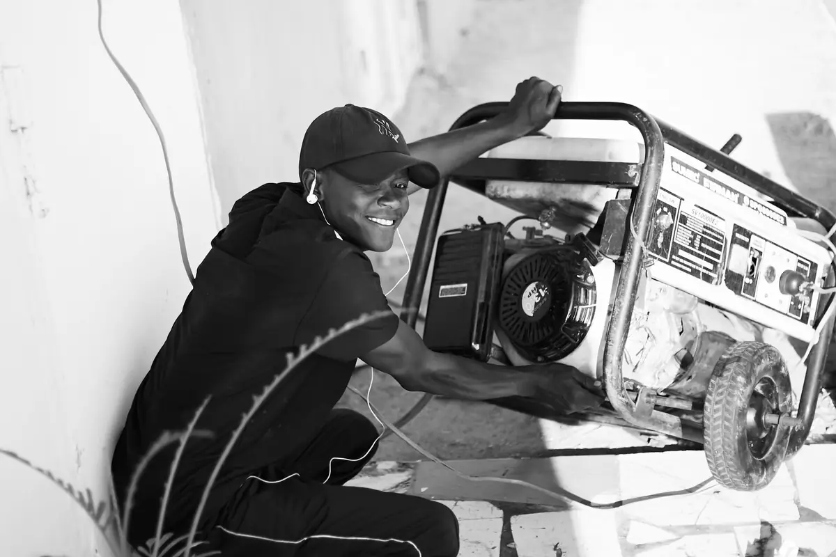 A man moving a portable gas generator outside