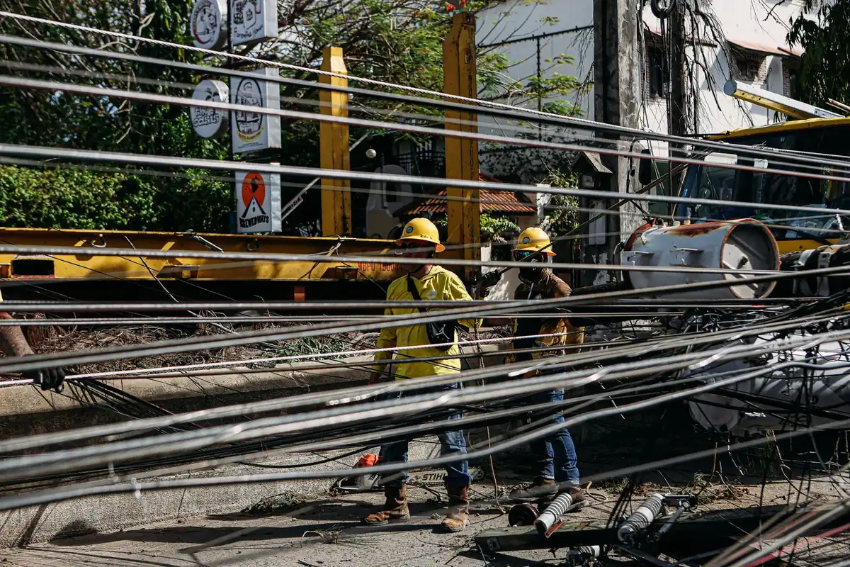 Utility workers repairing downed power lines on a street