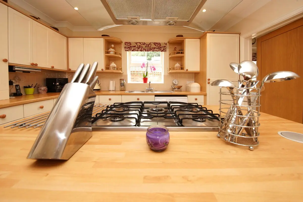 A stainless knife block on a kitchen island in front of a gas range