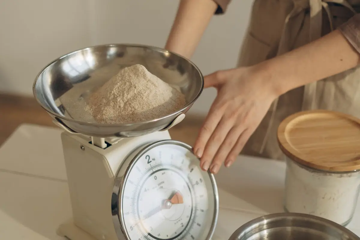 A baker weighing flour on a kitchen scale