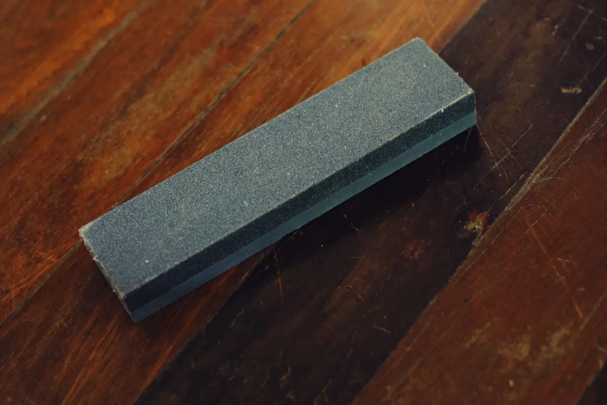 A two-sided sharpening stone on a wooden table