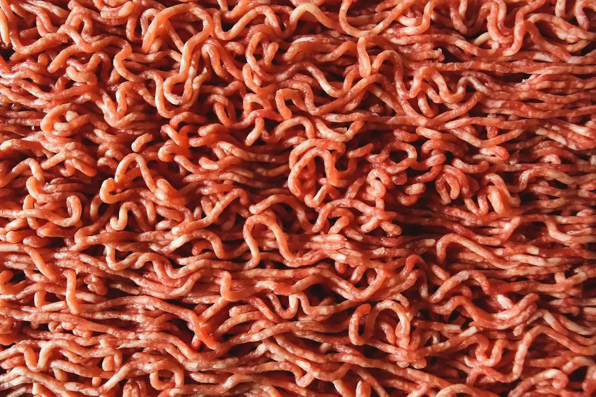 A close-up of freshly ground red meat
