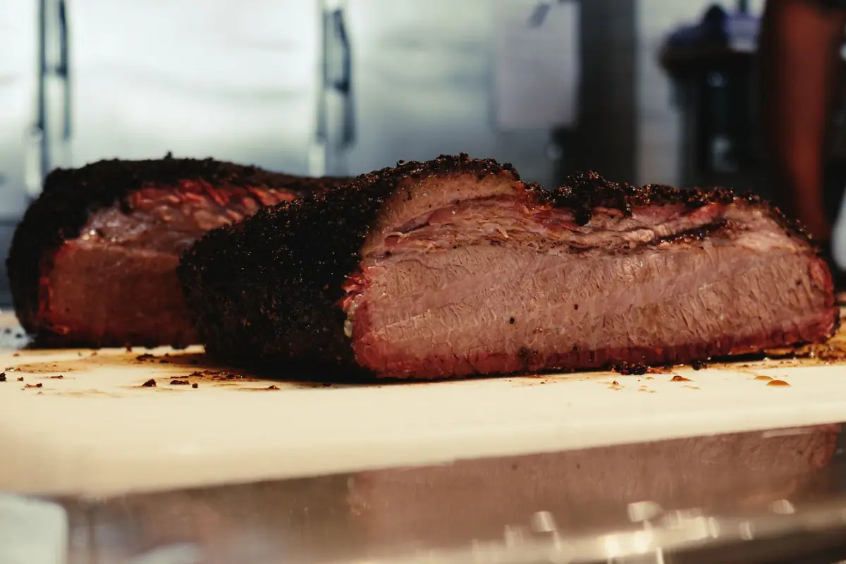 Two pieces of smoked brisket showing a pink smoke ring