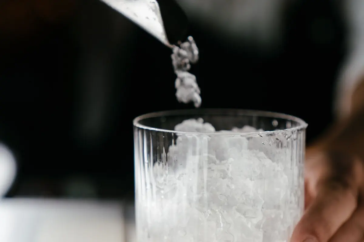 Crushed ice being poured into a clear glass