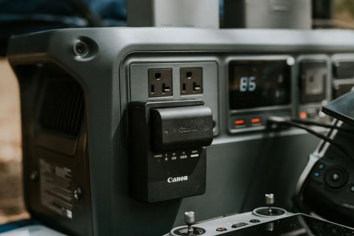 A portable power station with devices plugged into its outlets