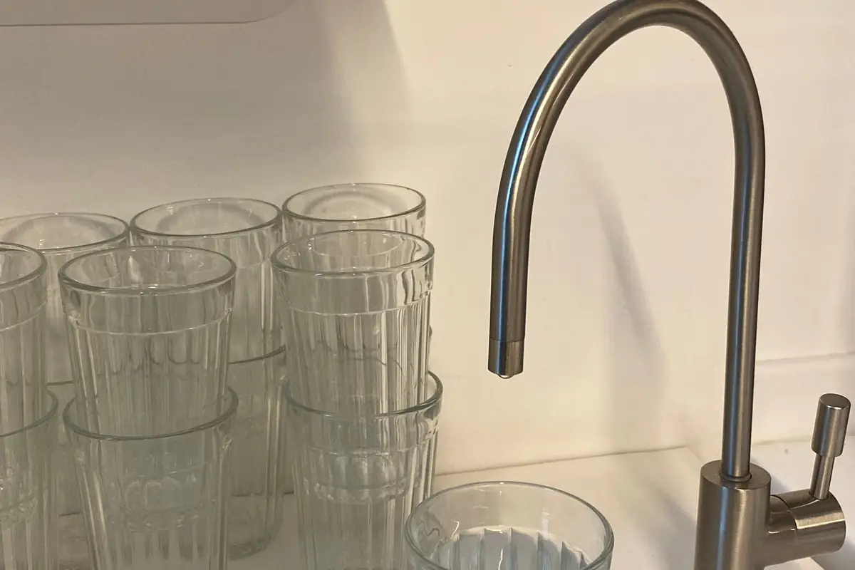 Drinking glasses next to a separate filtered-water faucet at a kitchen sink