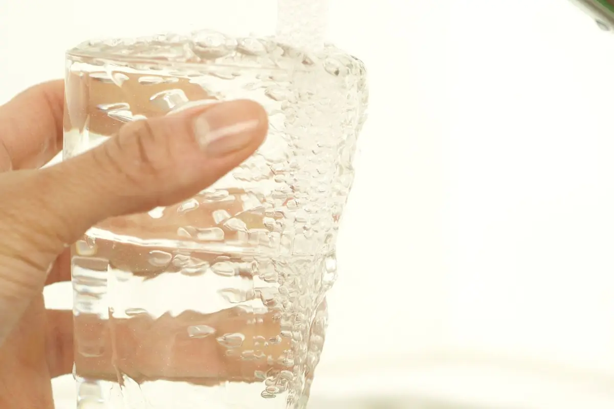 A glass filling with water from a kitchen tap