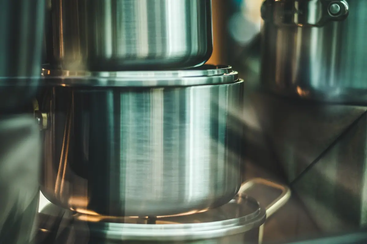 Shiny stainless steel pots stacked on a counter