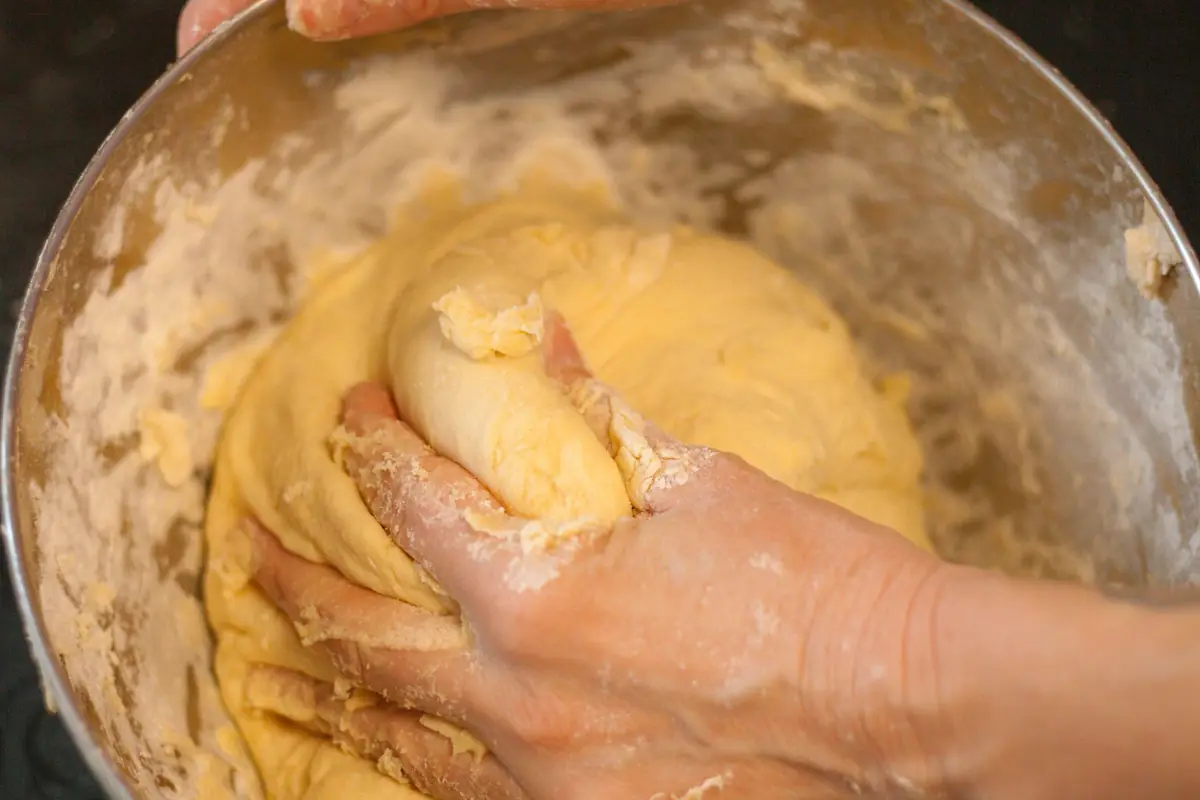 Bread dough being worked in a mixing bowl