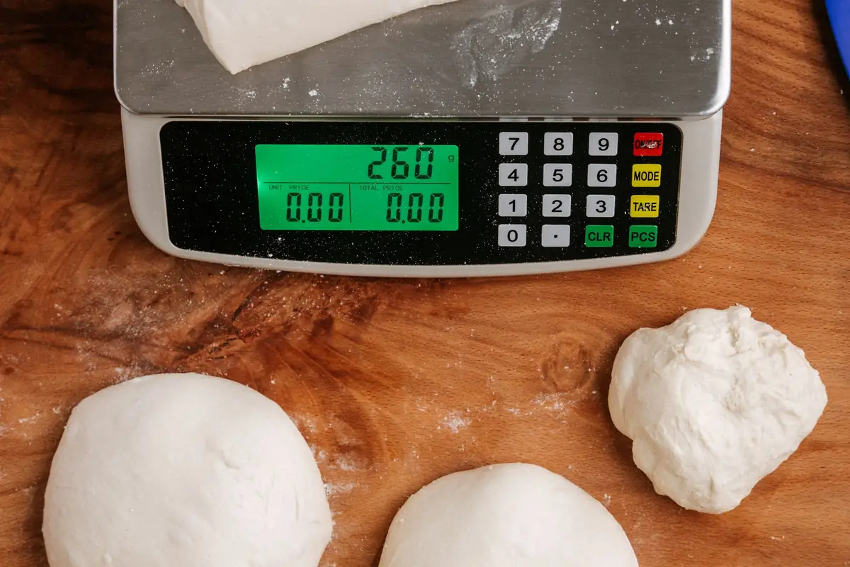 Portioned dough balls weighed on a digital kitchen scale