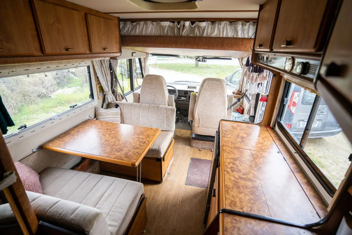 The wood-paneled interior of a camper with a dinette