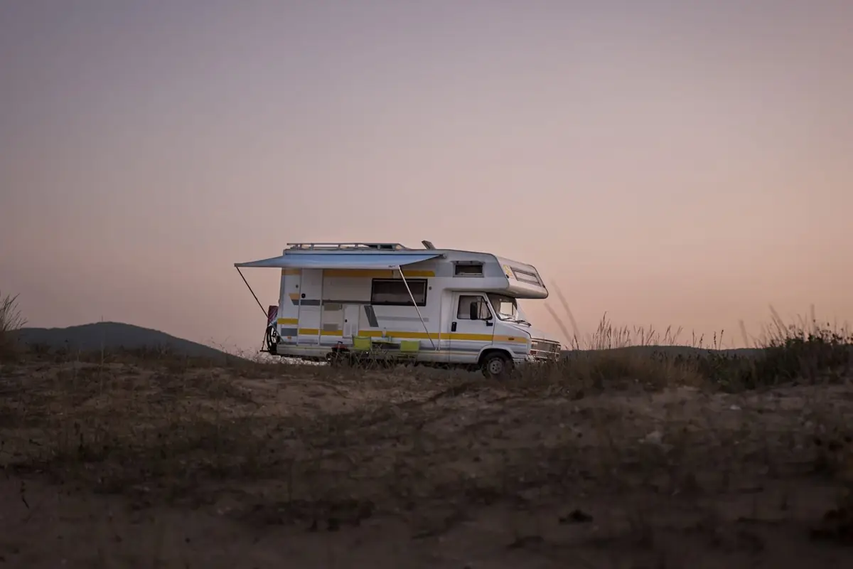 A motorhome parked on a hillside at dusk