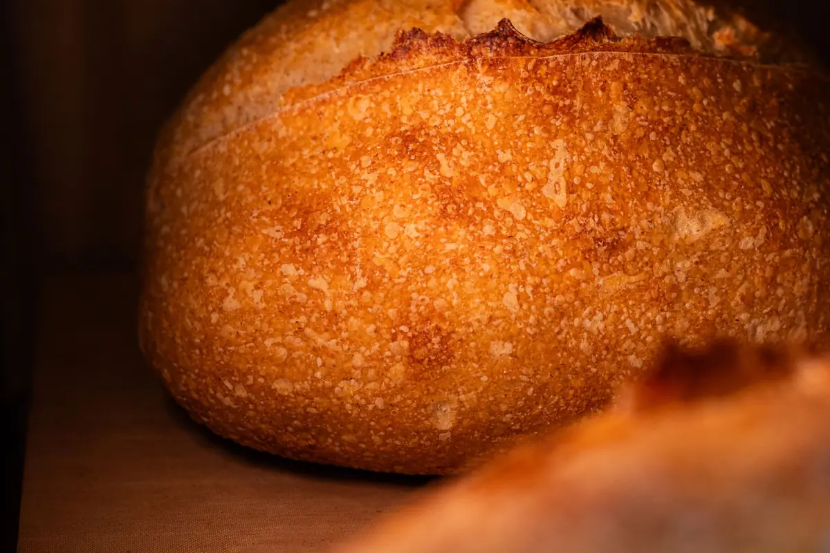A golden brown sourdough loaf with a deep score