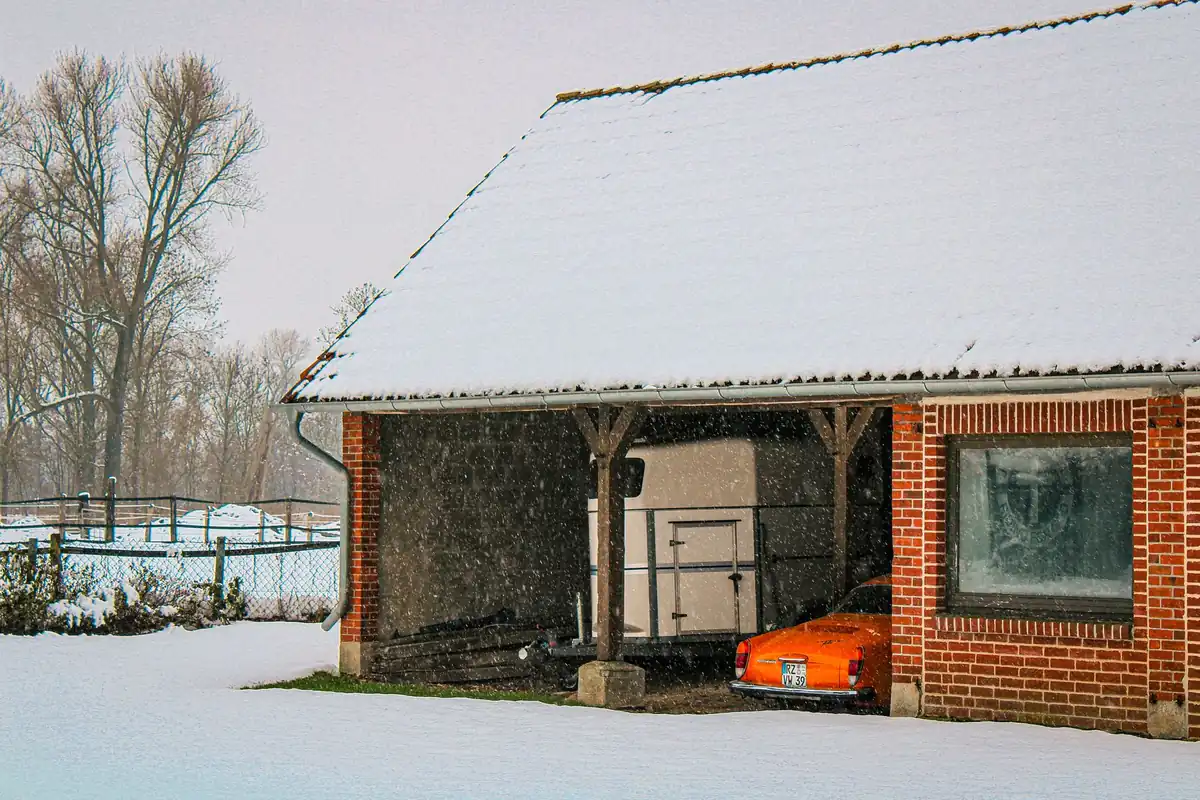 A snow-covered brick garage in winter