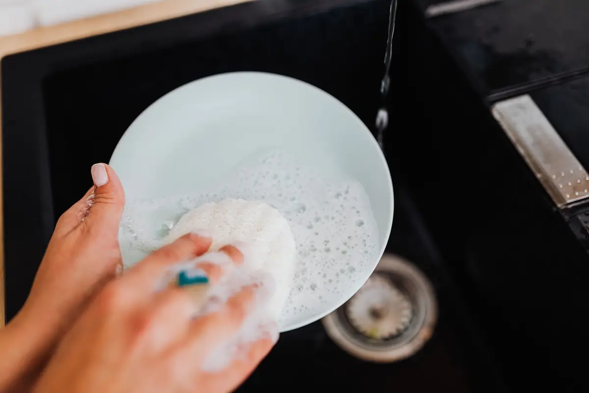 Washing a plate over a sink drain