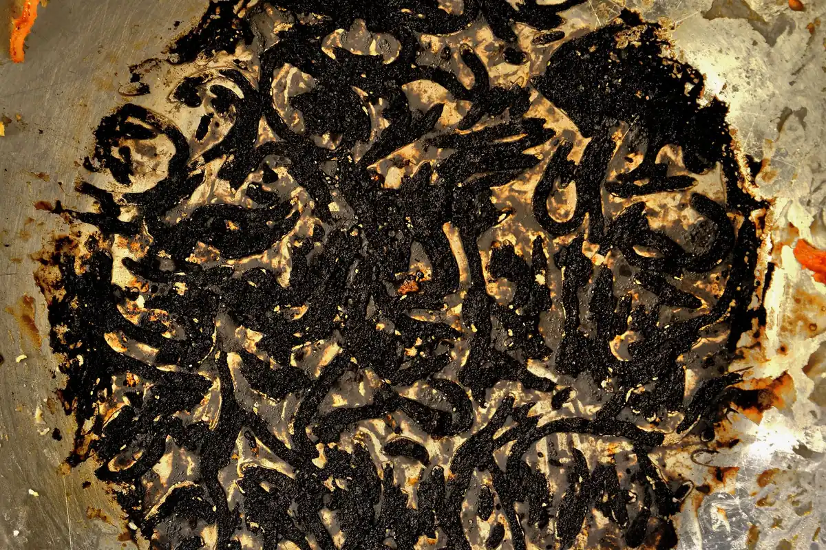 Burnt, blackened food stuck to the bottom of a pan