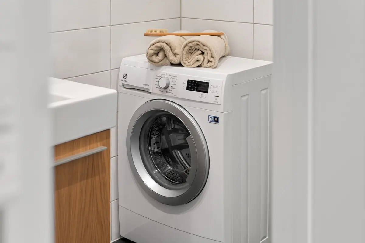 Rolled towels on top of a front-load washer with its door closed