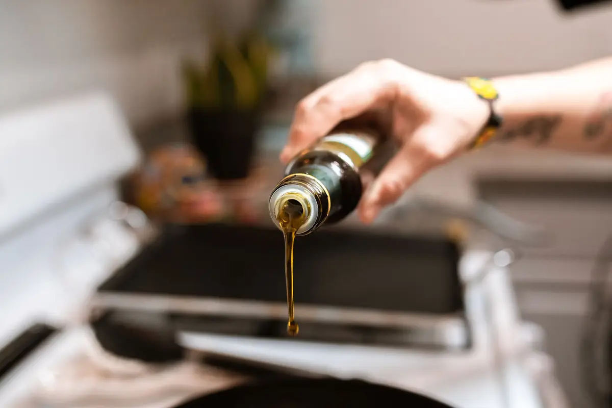Cooking oil being poured from a glass bottle