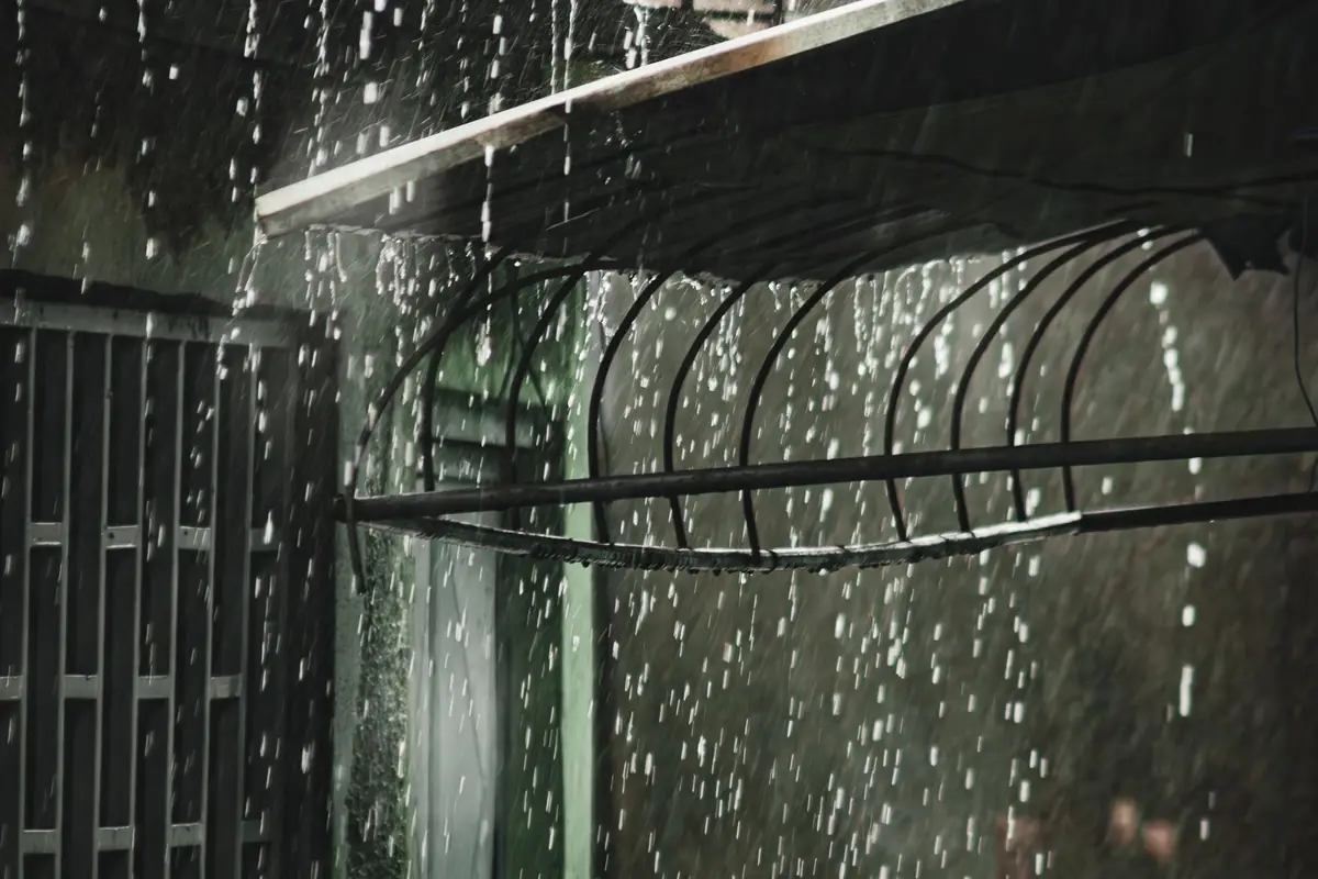 Heavy rain pouring off a roof edge