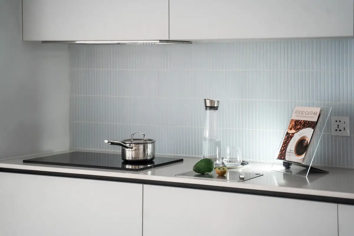 A small stainless pot on a built-in induction cooktop