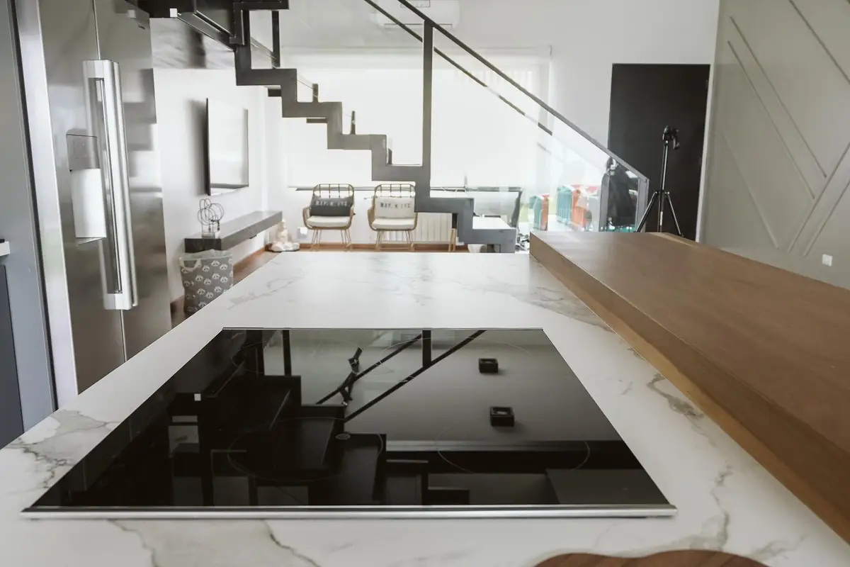 A black induction cooktop set into a marble kitchen island