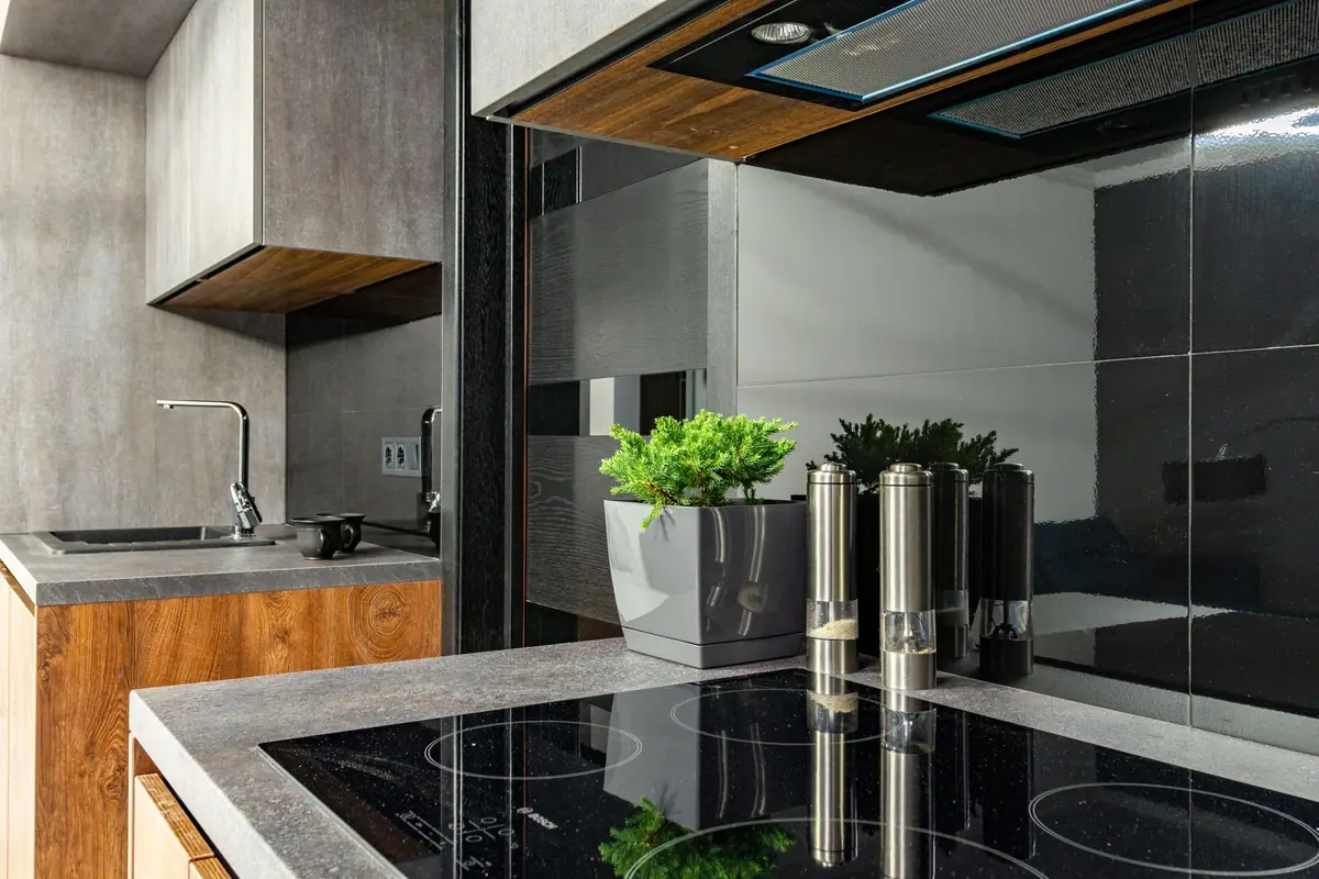 A modern kitchen with an induction cooktop under a range hood