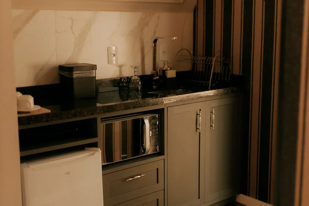 A compact kitchen with a mini fridge, microwave and coffee maker