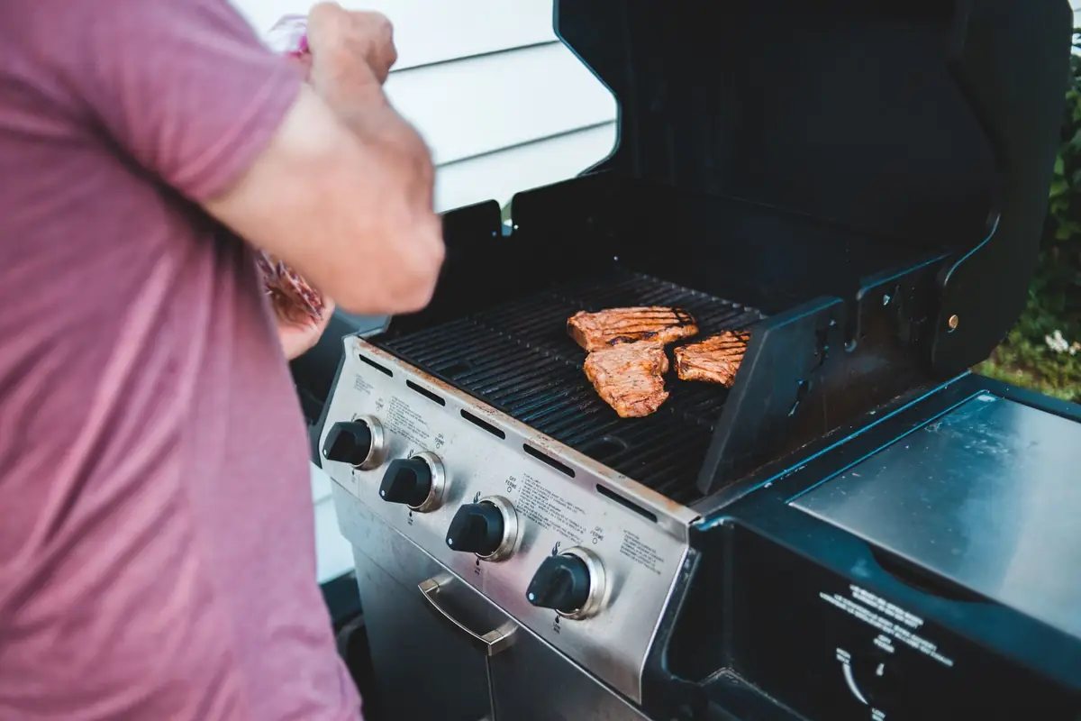 Steaks cooking on a stainless steel gas grill