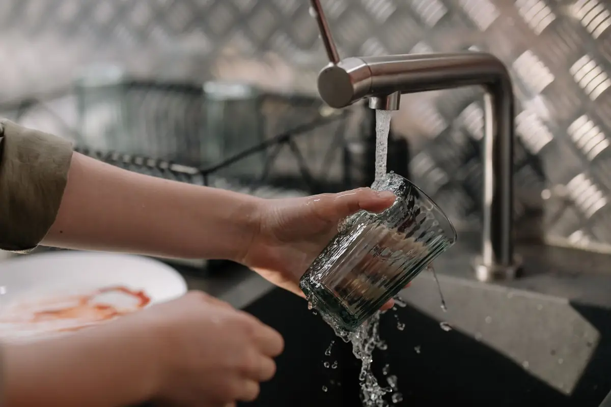 Rinsing a glass under a kitchen faucet