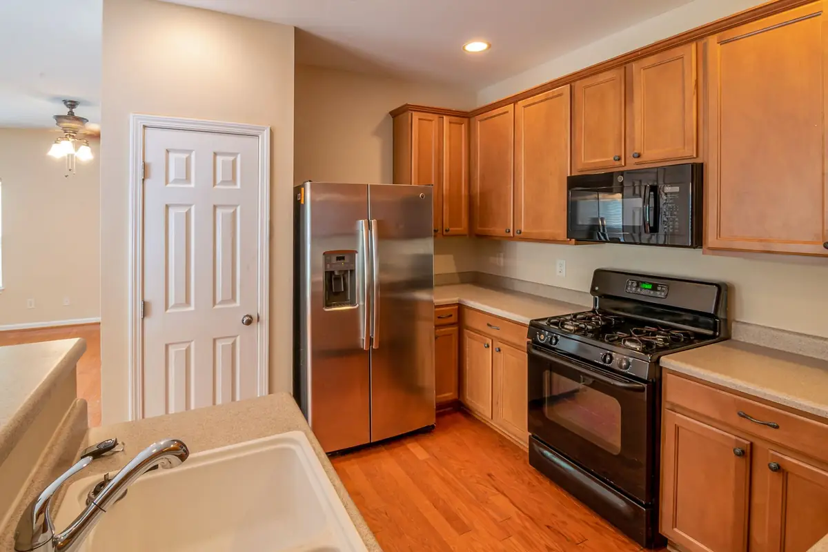 A kitchen with a stainless steel French door refrigerator and wooden cabinets